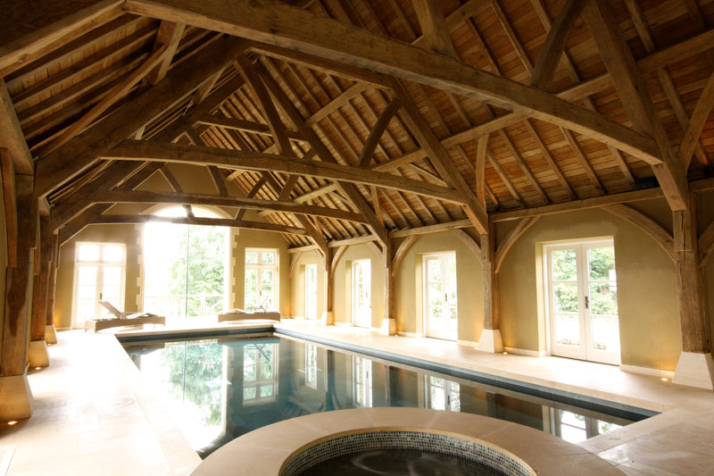 Indoor pool with wooden beams and large windows